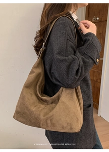 Detailed texture of brown suede hobo bag featuring a minimalist retro vibe and wide strap
