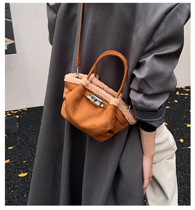 Detailed view of a brown suede bucket bag with beige plush trim and silver hardware details