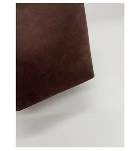 Detailed close-up showing high-quality dark brown matte suede texture of the bucket bag