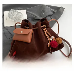 Detailed view of a brown frosted suede bucket bag with leather pouch and decorative tassels