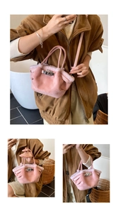 Detailed view of pink faux suede bucket bag with shearling trim and metal clasp