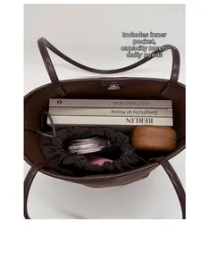 Interior view of large brown bucket bag showing a drawstring pouch and daily essentials