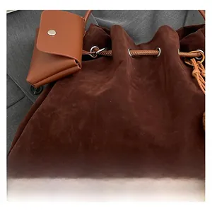 Close-up of deep brown matte suede bucket bag with drawstring and matching pouch