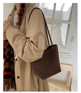 Detail of a large brown suede tote bag worn on shoulder for stylish daily commuting
