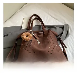Détails du cabas vintage en daim marron avec rivets métalliques et pendentifs créatifs