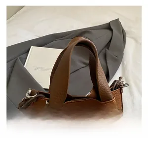 Gros plan du sac à main en cuir marron grainé avec bijou de sac lapin en peluche blanc