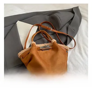 Detail of brown suede bucket bag with faux fur trim and silver metal twist lock clasp