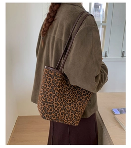 Detailed side view of large leopard print tote bag styled with a brown coat for daily commute