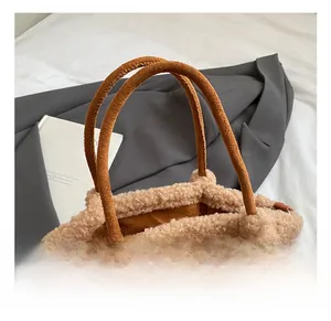 Detail of suede tote bag with faux fur trim, silver turn-lock and comfortable handle