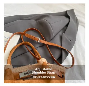 Detail of suede bucket bag with adjustable leather strap and silver metal clasp