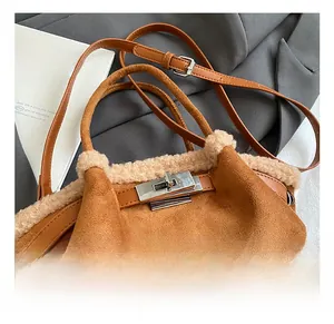 Close-up of brown suede bucket bag with beige shearling trim and silver twist lock