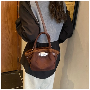 Detailed view of brown suede bucket bag with plush trim and adjustable leather strap
