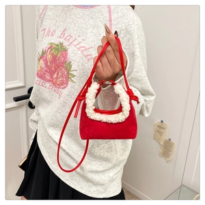 Detail of red suede dumpling bag with white faux fur trim and adjustable shoulder strap