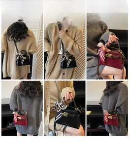 Detail view of retro suede crossbody bag with silk scarf handle and metal lock