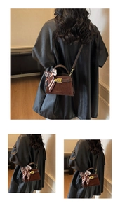 Detail of brown suede Kelly bag with metallic twist lock and silk scarf wrapped handle