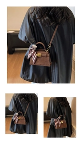 Detail of a brown suede mini handbag with silk scarf handle and metal turn-lock closure