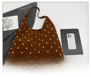 Detailed close-up of brown suede hobo bag featuring silver stud rivets and a spacious interior