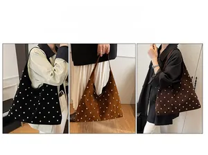 Detail of studded hobo shoulder bag with pearl accents and wide strap in soft matte leather
