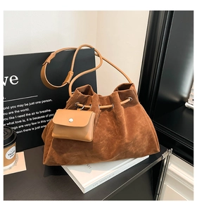 Detailed close-up of brown suede bucket bag with drawstring and matching pouch