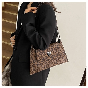Detail of vintage leopard print crossbody bag with silver clasp on female model