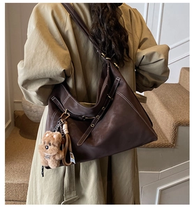 Detail view of large vintage tote bag with contrast stitching and bear charm