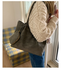 Vue détaillée du grand sac cabas en daim gris avec pochette assortie et marquage