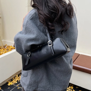 Detailed back view of a minimalist black leather underarm bag with silver buckle strap