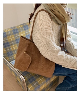 Close-up of brown suede tote bag featuring a small matching half-moon zipper pouch