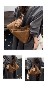 Macro shot of brown suede tote bag with contrast stitching and teddy bear charm