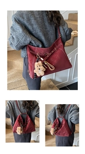 Detailed view of burgundy multifunctional suede convertible backpack with cute bear charm and straps.