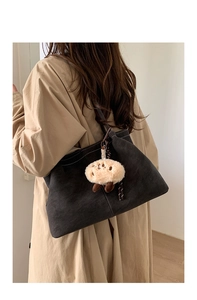 Detail of dark charcoal tote bag with contrast stitching and plush sheep pendant charm