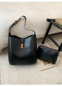 Detail view of the black soft leather bucket bag with golden buckle and matching pouch