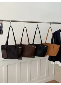 Detailed row of large tote bags in coffee, brown, and black with delicate shoulder straps