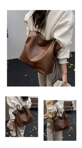 Detailed macro view of dark brown tote bag texture with gold chain and metal hardware