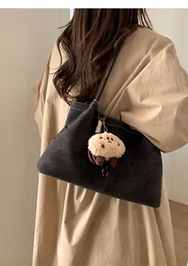 Close-up of a large grey tote bag with white stitching and a cute fluffy animal charm