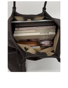 Spacious interior of a dark brown faux suede tote bag holding a laptop and books