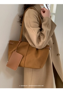 Detailed side view of a large brown leather tote bag with matching hanging coin purse