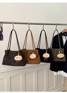 Detail view of large suede tote bags in four colors with plush animal charms
