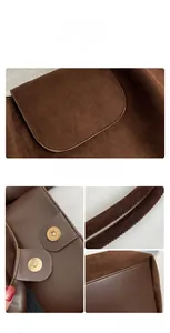 Detail of brown faux suede tote bag showing magnetic gold buckle and leather texture