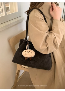 Minimalistische schwarze Wildleder-Einkaufstasche mit süßem Plüsch-Schaf-Anhänger am Schultergurt