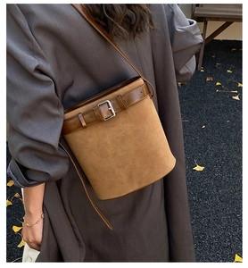 Détail du sac seau en daim caramel avec bandoulière en cuir et boucle argentée