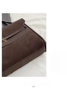 Detail of dark brown pebble leather handbag with premium gold metal buckle and stitching