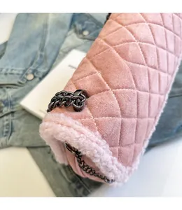 Détail du sac à bandoulière rose matelassé avec bordure en fourrure et chaîne noire
