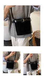 Détail du sac seau noir avec coutures en daim et une boucle en métal argenté élégante