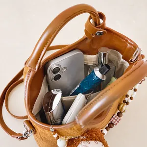 Detailaufnahme des Innenraums einer braunen Beuteltasche mit Stauraum für Essentials