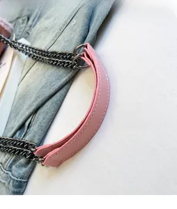 Detail of pink leather shoulder strap with dark gunmetal chain and dense white stitching