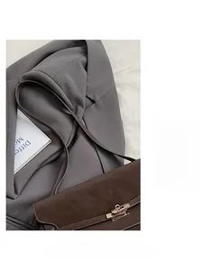 Detail of vintage dark brown faux leather tote with elegant gold twist lock and slim strap