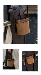 Détail du sac seau en daim marron avec boucle de ceinture en cuir et bandoulière