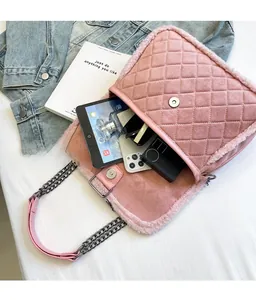 Pink quilted shoulder bag with faux fur trim showing interior storage for a tablet and phone