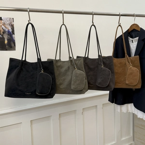 Détails de quatre sacs cabas en cuir mat de différentes couleurs sur un support métal